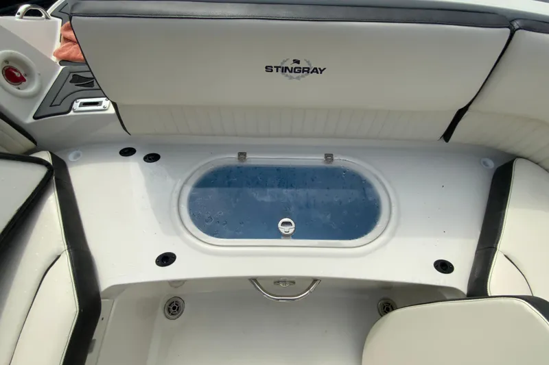 Slide: The Image of 2023 Stingray 231 DC boat interior with seating and storage compartment. - 23