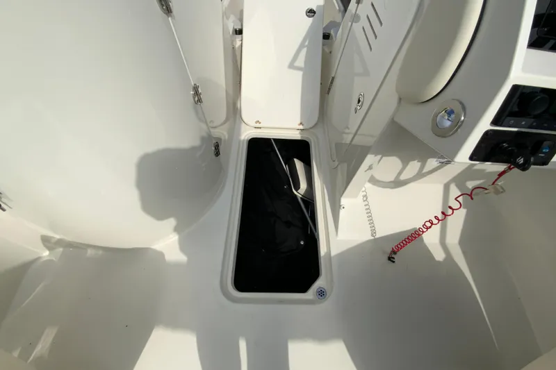 Slide: The Image of 2023 Stingray 231 DC boat interior with storage compartment and control panel. - 25