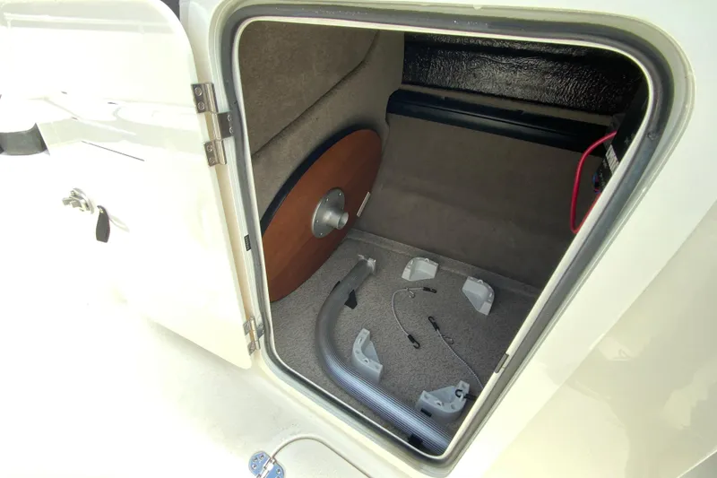 Slide: The Image of Storage compartment of 2023 Stingray 231 DC boat, featuring interior components and wiring. - 26