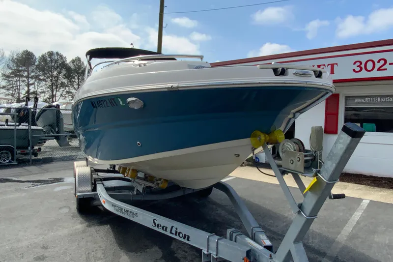Slide: The Image of 2023 Stingray 231 DC boat on trailer, parked outside dealership. - 3