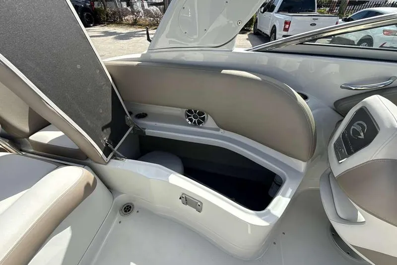 Slide: The Image of 2021 Crownline 255 XSS boat interior with open storage compartment and seating. - 13