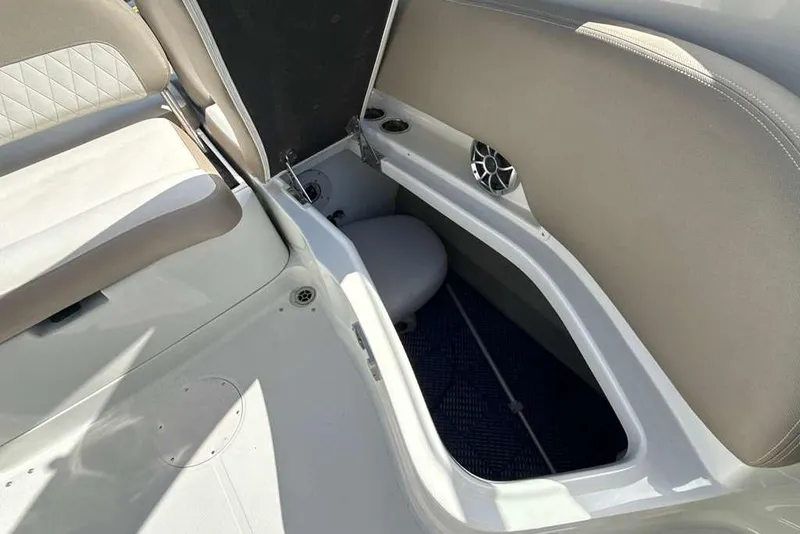 Slide: The Image of 2021 Crownline 255 XSS boat interior storage compartment with seating and speaker. - 14