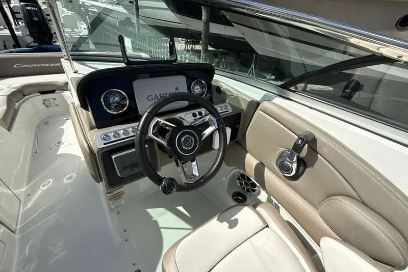 Slide: The Image of 2021 Crownline 255 XSS boat interior with steering wheel and Garmin display. - 18