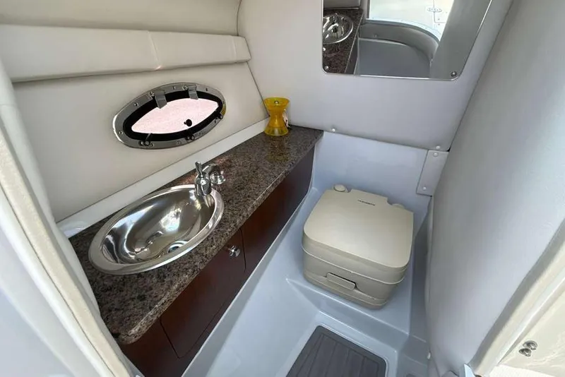 Slide: The Image of 2021 Crownline 255 XSS boat bathroom with sink, mirror, and portable toilet. - 20