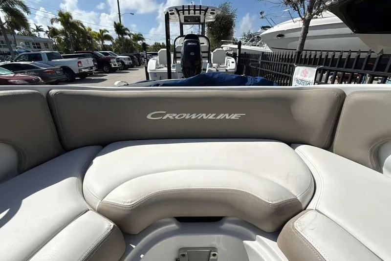 Slide: The Image of 2021 Crownline 255 XSS boat interior with beige seating, parked outdoors. - 32