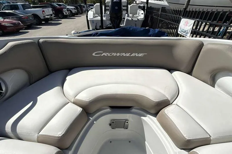 Slide: The Image of 2021 Crownline 255 XSS boat interior with cushioned seating in a parking lot. - 36