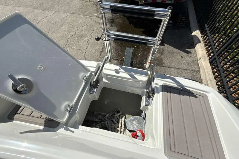 Slide: The Image of Open storage compartment on 2021 Crownline 255 XSS boat with ladder and ropes. - 41