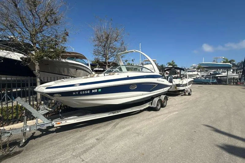 Slide: The Image of 2021 Crownline 255 XSS boat on trailer in sunny marina setting. - 43