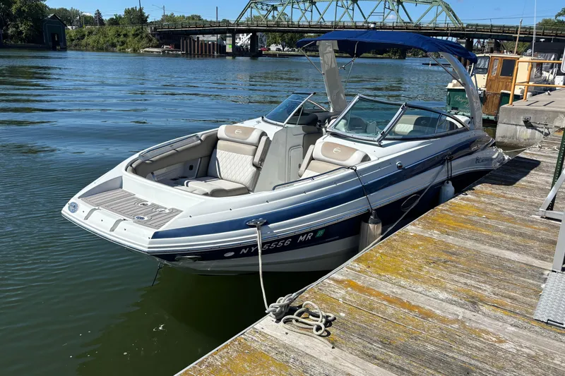 Slide: The Image of 2021 Crownline 255 XSS boat docked on a sunny day by a wooden pier. - 44