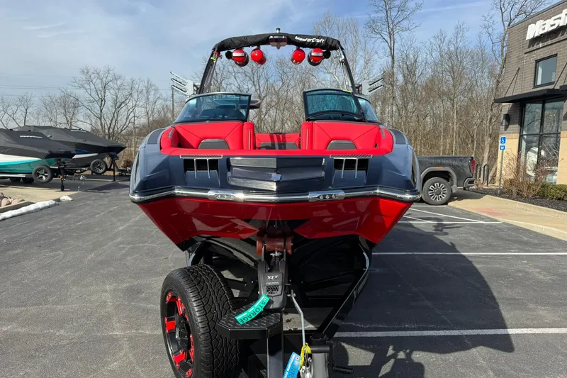 Slide: The Image of 2020 MasterCraft XStar boat on trailer, vibrant red and black design, parked outdoors. - 11