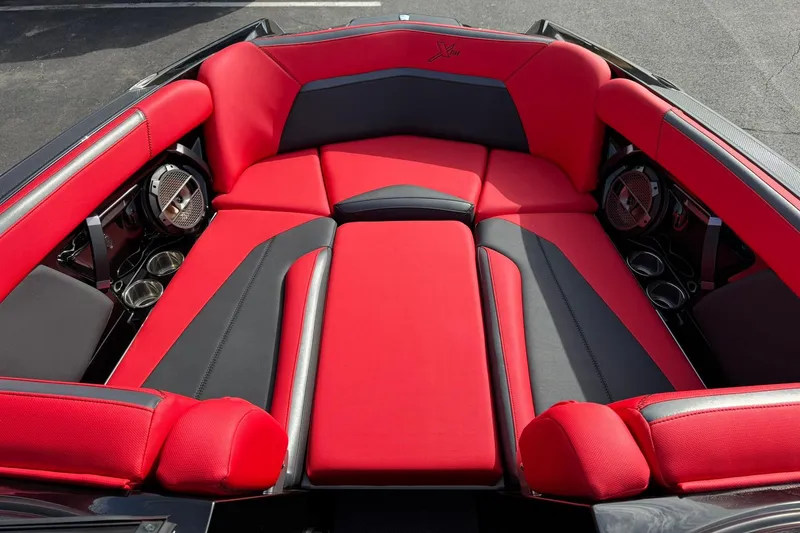 Slide: The Image of 2020 MasterCraft XStar boat interior with red and black seating, featuring cup holders and speakers. - 12
