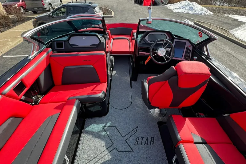 Slide: The Image of 2020 MasterCraft XStar boat interior with red and black seating, modern dashboard, and steering wheel. - 23