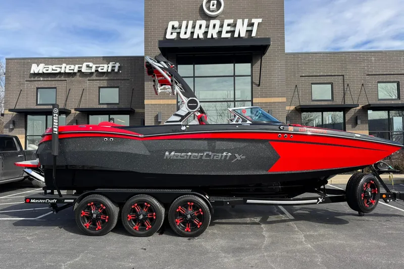Slide: The Image of 2020 MasterCraft XStar boat in red and black, parked outside dealership. - 3