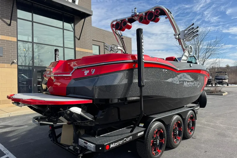 Slide: The Image of 2020 MasterCraft XStar boat with red and black design on a trailer. - 6