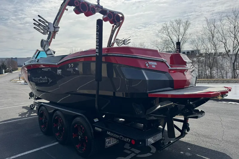 Slide: The Image of 2020 MasterCraft XStar boat on trailer, red and black design, parked outdoors. - 8