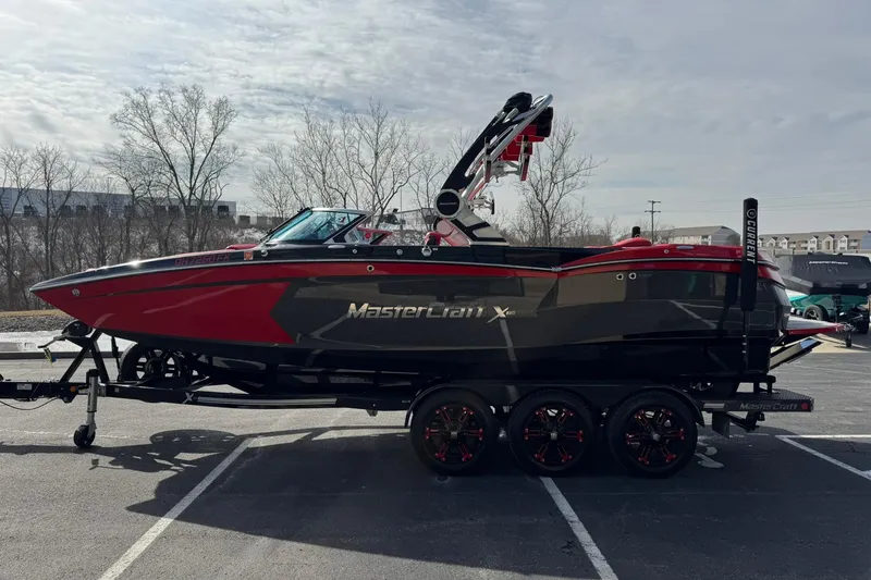 Slide: The Image of 2020 MasterCraft XStar boat on trailer, red and black design, parked outdoors. - 9