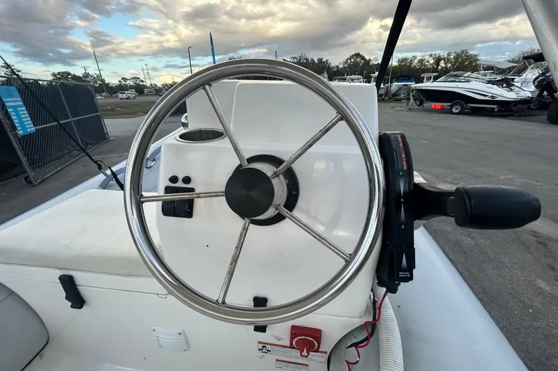 Slide: The Image of 2021 AB Inflatables Mares 10 VSX steering wheel and controls, docked under cloudy sky. - 15