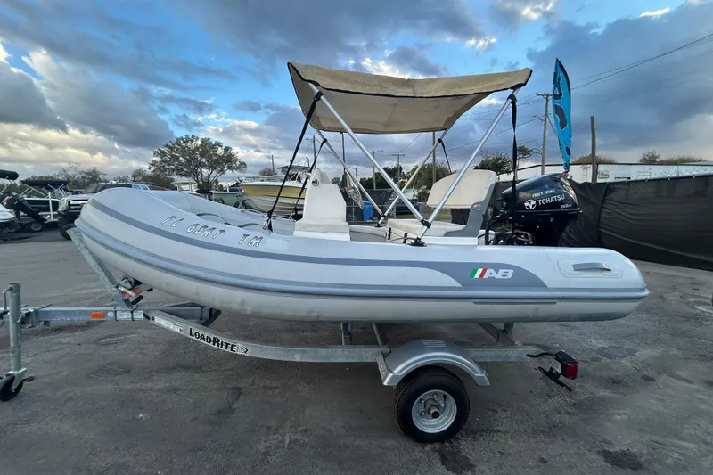 Slide: The Image of 2021 AB Inflatables Mares 10 VSX boat on trailer, with Tohatsu engine, under cloudy sky. - 8