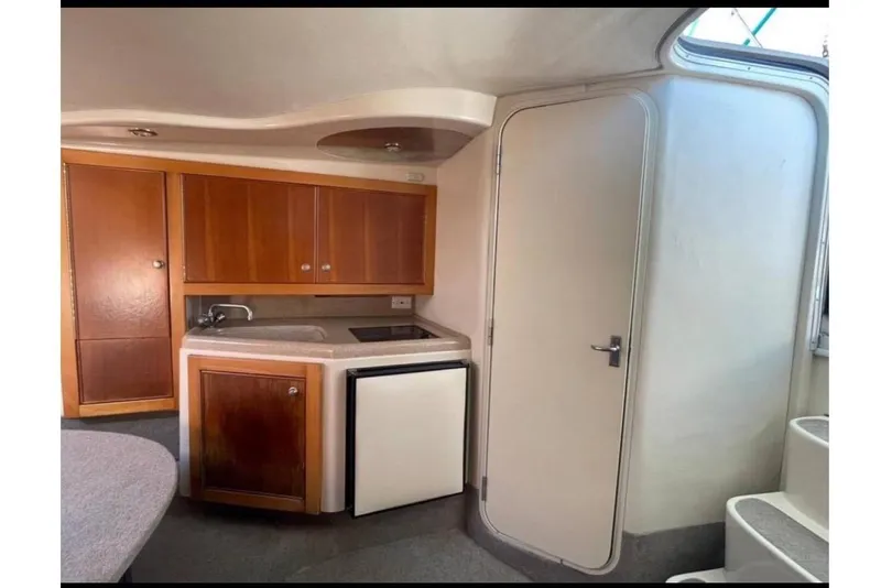 Slide: The Image of Interior of 2000 Riviera 3000 Offshore yacht with kitchenette and cabinets. - 11