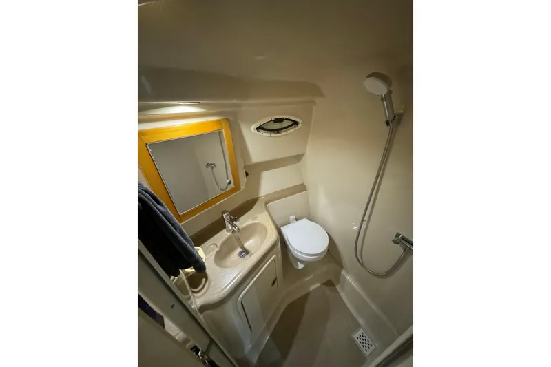 Slide: The Image of Compact bathroom in 2000 Riviera 3000 Offshore boat with shower, sink, and toilet. - 14
