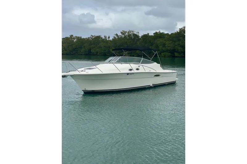 Slide: The Image of 2000 Riviera 3000 Offshore boat on calm water, overcast sky, lush green background. - 17