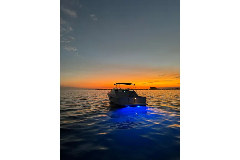 Slide: The Image of Riviera 3000 Offshore boat at sunset with blue underwater lights, 2000 model. - 21