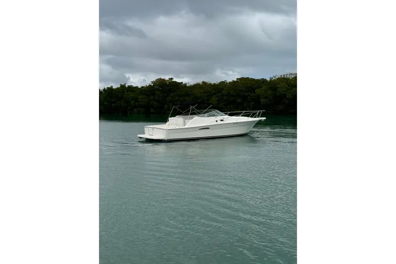 Slide: The Image of 2000 Riviera 3000 Offshore boat on calm water under cloudy sky. - 23
