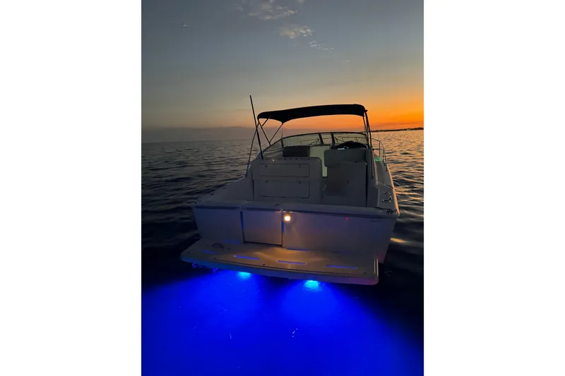 Slide: The Image of Riviera 3000 Offshore boat at sunset with blue underwater lights, 2000 model. - 24