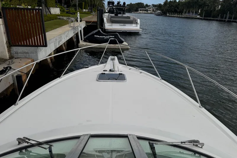 Slide: The Image of Bow view of 2000 Riviera 3000 Offshore yacht docked by waterfront homes. - 8