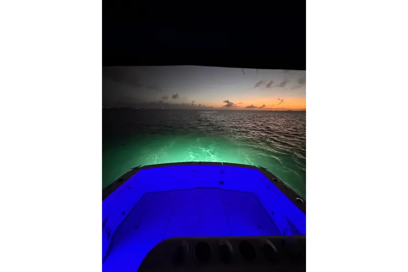 Slide: The Image of Riviera 3000 Offshore boat at sunset, illuminated deck, ocean view, 2000 model. - 9