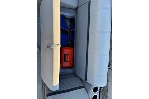 Slide: The Image of 2023 Angler Quest 8522 All Sport boat storage compartment with life jackets and a red toolbox. - 14