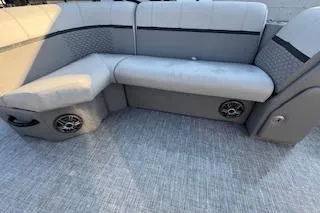 Slide: The Image of 2023 Angler Quest 8522 All Sport boat interior with gray cushioned seating and built-in speakers. - 22