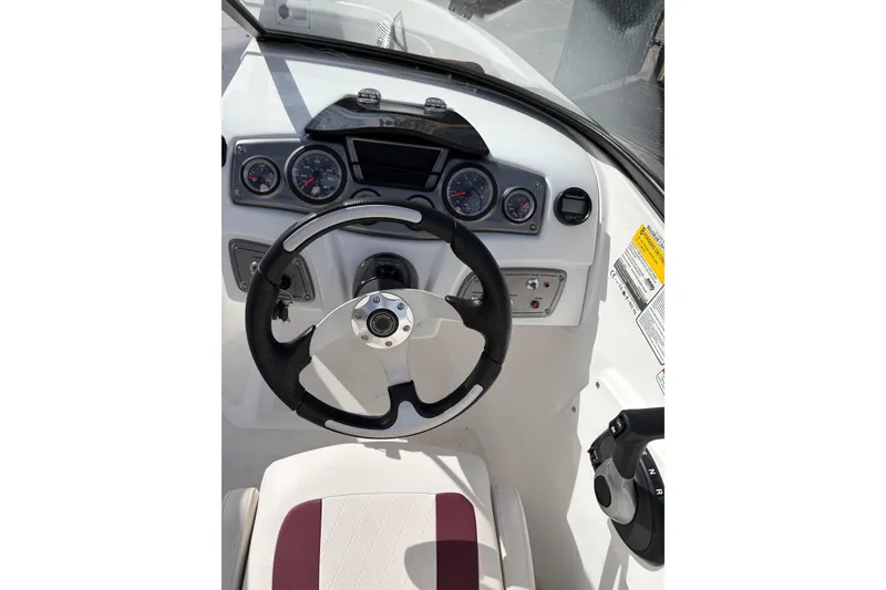 Slide: The Image of 2023 Tahoe 200 S boat dashboard with steering wheel and gauges. - 2