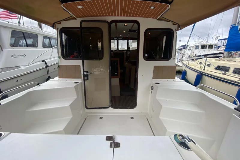 Slide: The Image of 2010 Ranger Tugs R-29 boat interior with open cockpit and docked yachts in background. - 11