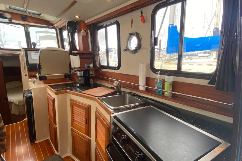 Slide: The Image of Interior of 2010 Ranger Tugs R-29 boat featuring a compact kitchen area. - 15