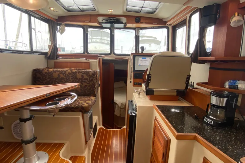 Slide: The Image of Interior of 2010 Ranger Tugs R-29 boat with seating, table, and kitchenette. - 16
