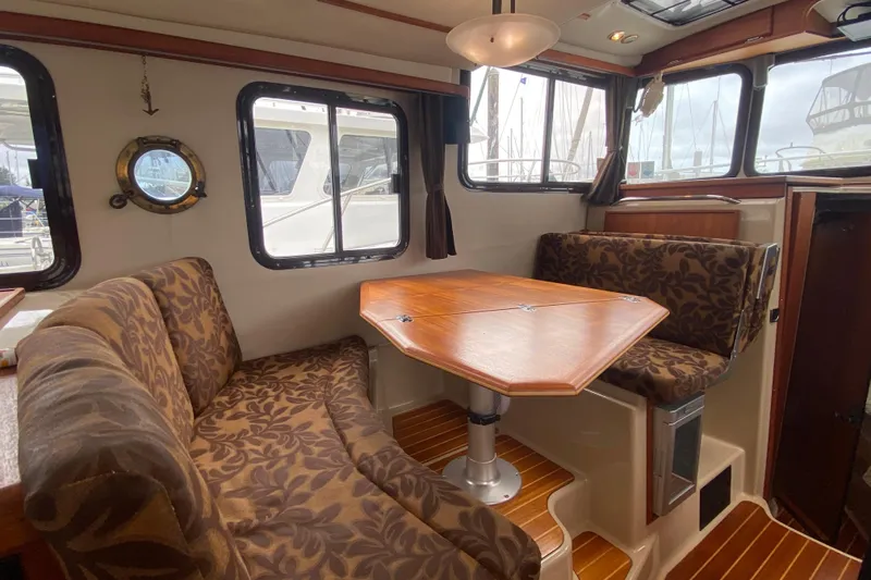 Slide: The Image of Interior of 2010 Ranger Tugs R-29 with patterned seating and wooden table. - 17