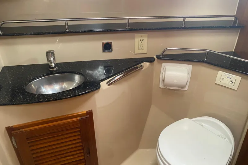 Slide: The Image of 2010 Ranger Tugs R-29 boat bathroom with sink, toilet, and storage cabinet. - 23