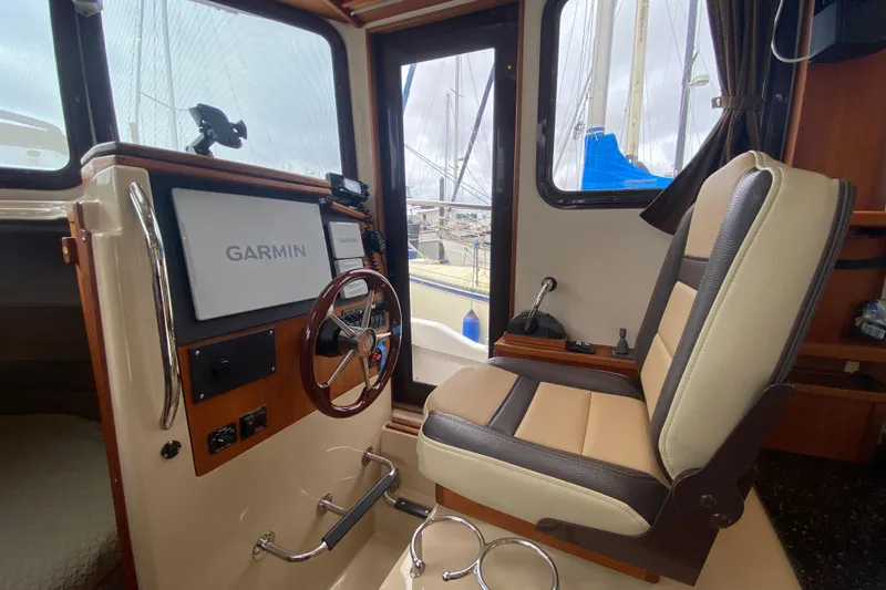 Slide: The Image of 2010 Ranger Tugs R-29 helm with Garmin navigation system and comfortable captain's chair. - 24