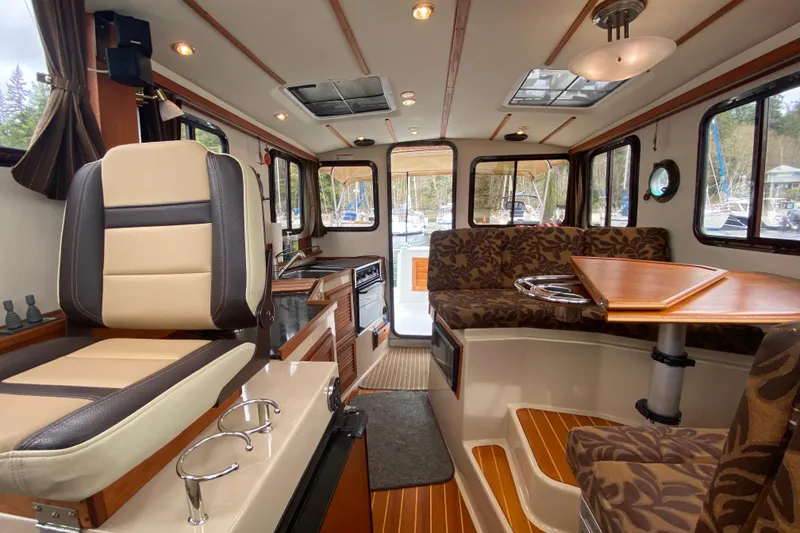 Slide: The Image of Interior of 2010 Ranger Tugs R-29 boat with seating, table, and helm station. - 25