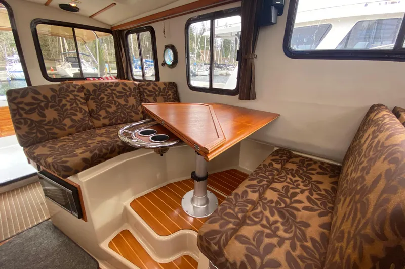 Slide: The Image of Interior of 2010 Ranger Tugs R-29 with patterned seating and wooden table. - 26