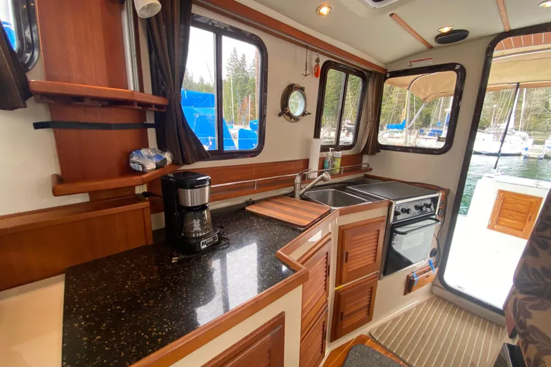 Slide: The Image of Interior of 2010 Ranger Tugs R-29 boat featuring a compact kitchen area. - 27