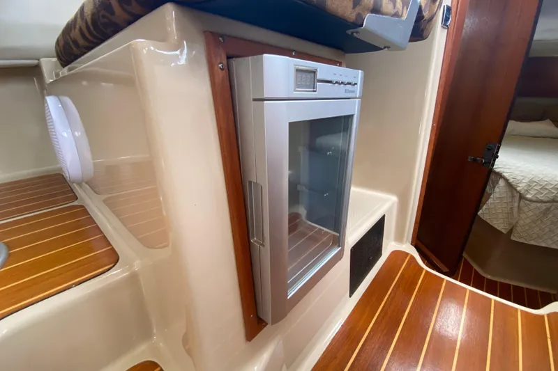 Slide: The Image of 2010 Ranger Tugs R-29 interior with wood flooring and compact refrigerator. - 29