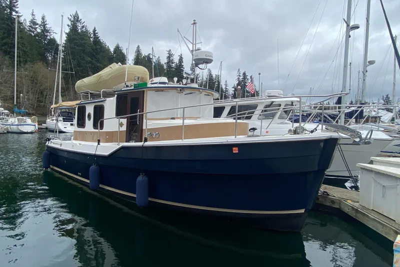 Slide: The Image of 2010 Ranger Tugs R-29 boat docked in a marina, surrounded by other vessels. - 3
