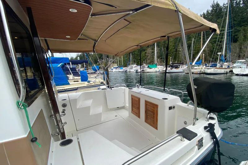 Slide: The Image of 2010 Ranger Tugs R-29 boat docked in a marina with canopy and seating area. - 8