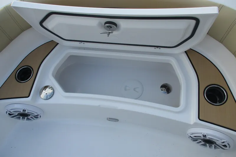 Slide: The Image of 2026 Sportsman Masters 267OE Bay Boat storage compartment with speakers and cup holders. - 12