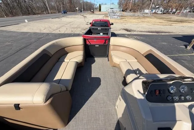 Slide: The Image of 2022 Viaggio Lago 22U pontoon boat with beige seating and dashboard, parked on a trailer. - 17