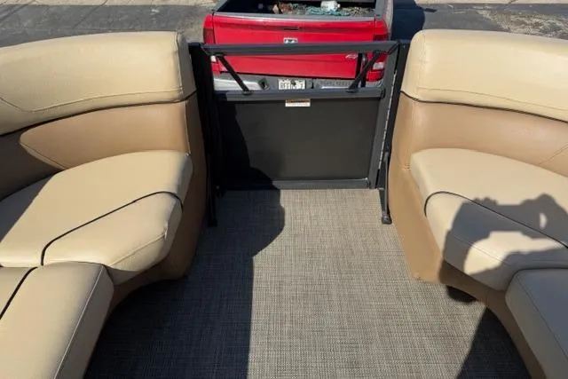 Slide: The Image of 2022 Viaggio Lago 22U boat interior with beige seating and a view of a red truck. - 19