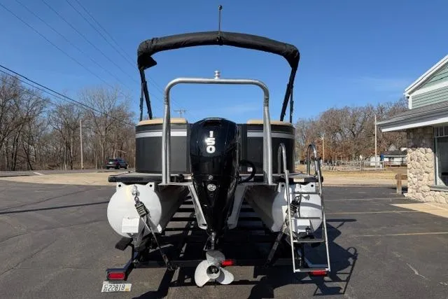 Slide: The Image of 2022 Viaggio Lago 22U pontoon boat with 150 HP engine, parked outdoors. - 2