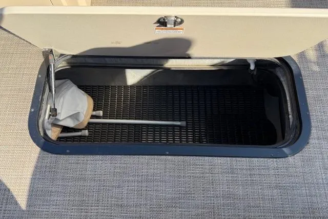 Slide: The Image of Open storage compartment in 2022 Viaggio Lago 22U boat, featuring a net and handle. - 29